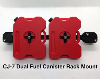 May include: A CJ-7 dual fuel canister rack mount featuring two bright red rectangular fuel canisters secured to a horizontal black mounting bracket with central black cross-shaped fasteners and silver metal screws at the ends.