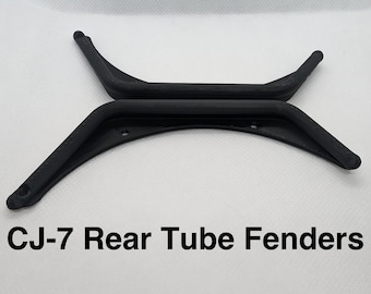 May include: Two black CJ-7 rear tube fenders with a textured finish. Each fender features a curved design with integrated mounting holes at the ends and along the inner edge. The text CJ-7 Rear Tube Fenders is printed below the components.
