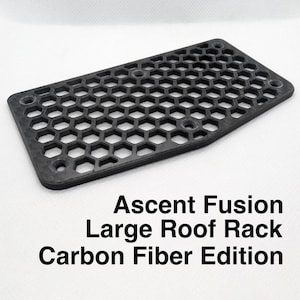 May include: A black carbon fiber roof rack for a car. The rack has a honeycomb pattern and is designed for carrying cargo on top of a vehicle. Ascent Fusion Large Roof Rack Carbon Fiber Edition.