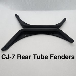 May include: A pair of black plastic CJ-7 rear tube fenders. The fenders are curved and have a textured surface.