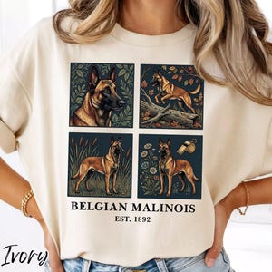 May include: Ivory-colored t-shirt featuring four square illustrations of Belgian Malinois dogs. The shirt includes the text "BELGIAN MALINOIS EST. 1892" in black font. The word "Ivory" is printed in a cursive font at the bottom left.