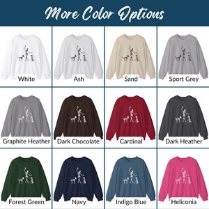 May include: A variety of color options for a sweatshirt featuring a skeleton playing fetch with two dogs. The sweatshirt is available in white, ash, sand, sport grey, graphite heather, dark chocolate, cardinal, dark heather, forest green, navy, indigo blue, and heliconia.