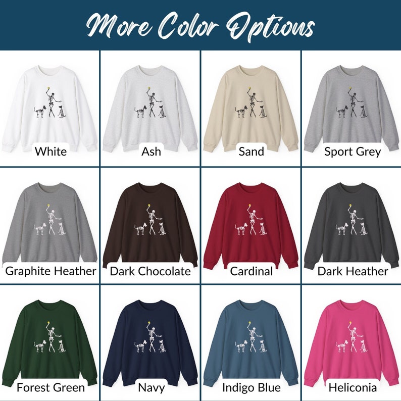 May include: A variety of color options for a sweatshirt featuring a skeleton playing fetch with two dogs. The sweatshirt is available in white, ash, sand, sport grey, graphite heather, dark chocolate, cardinal, dark heather, forest green, navy, indigo blue, and heliconia.