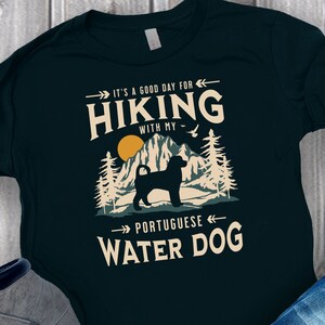 Hiking With My Portuguese Water Dog T-Shirt. A classic mountain design with Portuguese Water Dog silhouette, made for the Portie mom or dad who loves hiking with their dog. A great Portuguese Water Dog lover gift idea!