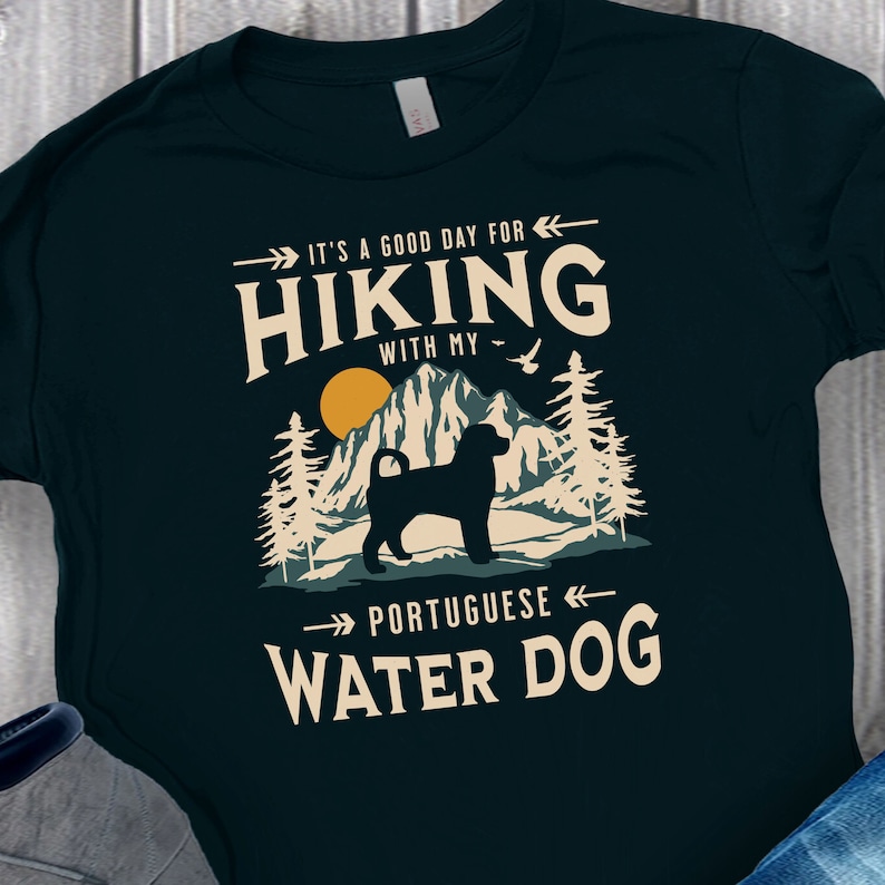 Hiking With My Portuguese Water Dog T-Shirt. A classic mountain design with Portuguese Water Dog silhouette, made for the Portie mom or dad who loves hiking with their dog. A great Portuguese Water Dog lover gift idea!