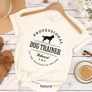 Balanced Dog Trainer T-Shirt: Fit the Training to the Dog. With a vintage style and handsome Belgian Malinois silhouette, its the perfect dog training apparel wear to appointments and lessons. And it makes a classy Malinois dog trainer gift!