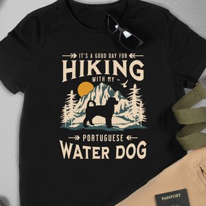 Hiking With My Portuguese Water Dog T-Shirt. A classic mountain design with Portuguese Water Dog silhouette, made for the Portie mom or dad who loves hiking with their dog. A great Portuguese Water Dog lover gift idea!