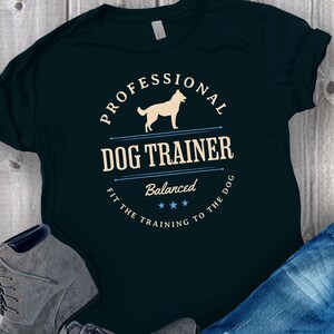 Balanced Dog Trainer T-Shirt: Fit the Training to the Dog. With a vintage style and handsome Belgian Malinois silhouette, its the perfect dog training apparel wear to appointments and lessons. And it makes a classy Malinois dog trainer gift!