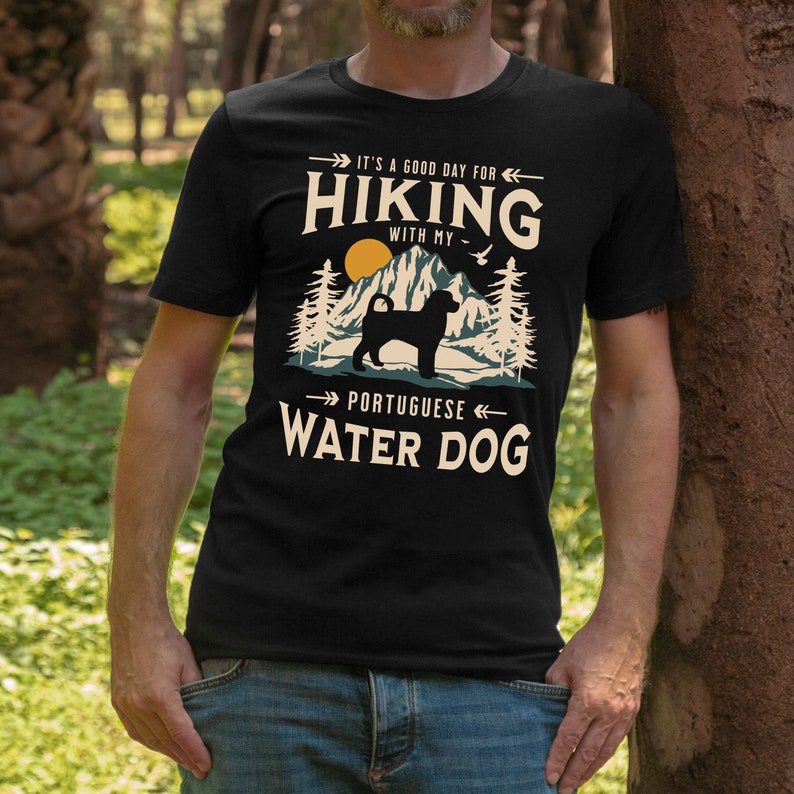 Hiking With My Portuguese Water Dog T-Shirt. A classic mountain design with Portuguese Water Dog silhouette, made for the Portie mom or dad who loves hiking with their dog. A great Portuguese Water Dog lover gift idea!