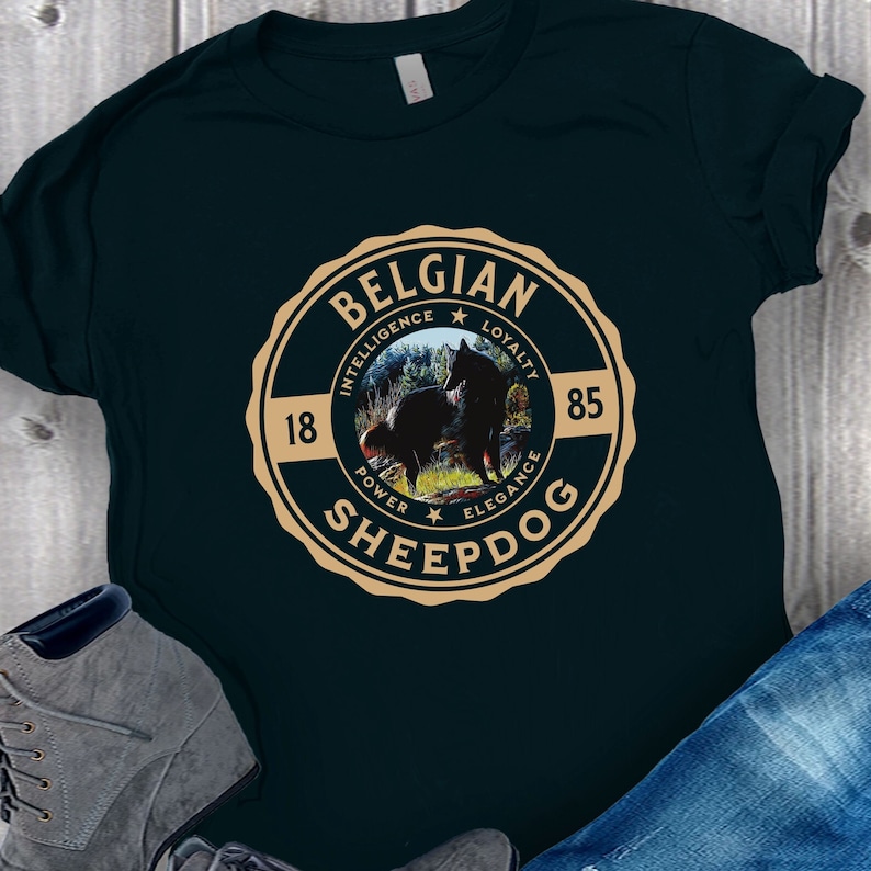 Op de afbeelding: Een donkergroen T-shirt met een bruine ronde afbeelding met een Belgische herder, de woorden "Belgian Sheepdog" en de woorden "Intelligentie, Loyaliteit, Kracht, Elegantie" rond de hondenafbeelding.