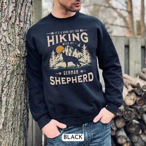 Hiking With My German Shepherd Sweatshirt. A beautiful and unique gift for the GSD lover in your life. With a classic mountain scene and handsome German Shepherd dog silhouette. Available in black and navy.