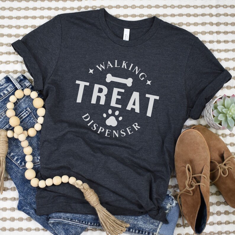 May include: A dark grey t-shirt with a white graphic that says "Walking Treat Dispenser" with a bone and paw print.