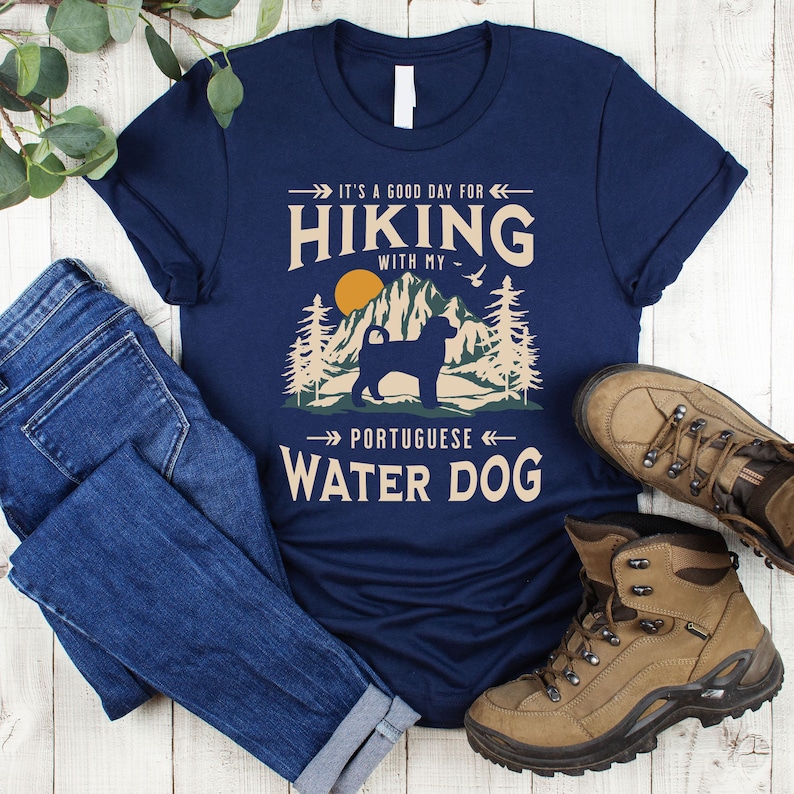 Hiking With My Portuguese Water Dog T-Shirt. A classic mountain design with Portuguese Water Dog silhouette, made for the Portie mom or dad who loves hiking with their dog. A great Portuguese Water Dog lover gift idea!