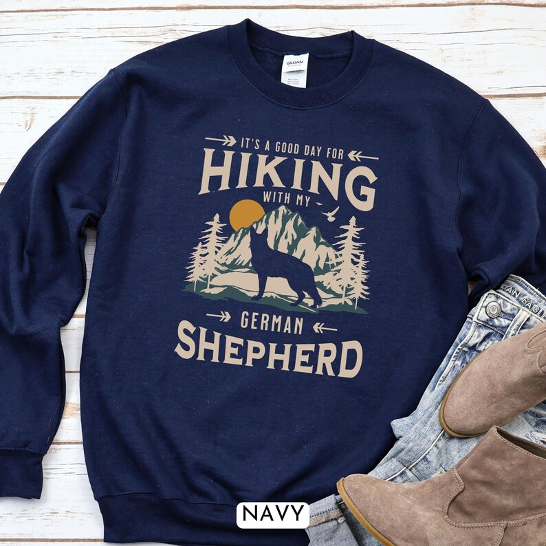 May include: Navy blue sweatshirt with a graphic of a German Shepherd dog standing on a mountain with the text "It's a good day for hiking with my German Shepherd".
