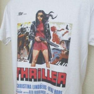 Könnte beinhalten: Weißes T-Shirt mit einem Filmplakat-Design. Die Grafik zeigt eine Frau mit einer Schrotflinte, das Wort "THRILLER" in Rot und die Namen "Christina Lindberg" und "Heinz Hopf".