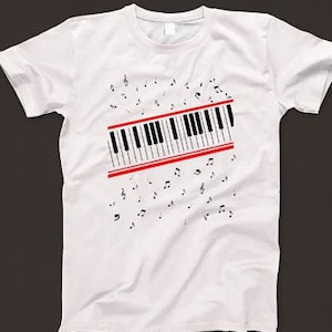 May include: White t-shirt featuring a black and white keyboard graphic with red accents. The keyboard is surrounded by musical notes.