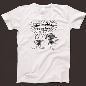 May include: White t-shirt with a black and white illustration of two stick figures and the text "the moldy peaches".