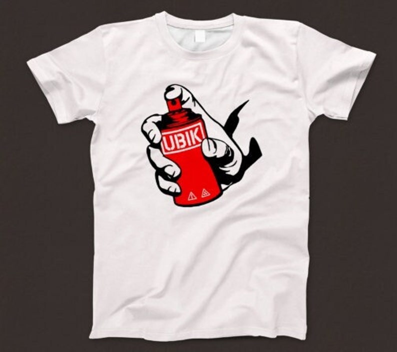 May include: White t-shirt with a red spray paint can graphic. The can has the word "UBIK" printed on it.