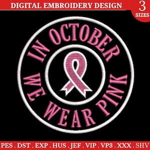 Peut inclure: Broderie de ruban rose avec le texte "In October We Wear Pink" dans un cercle blanc avec un contour noir.