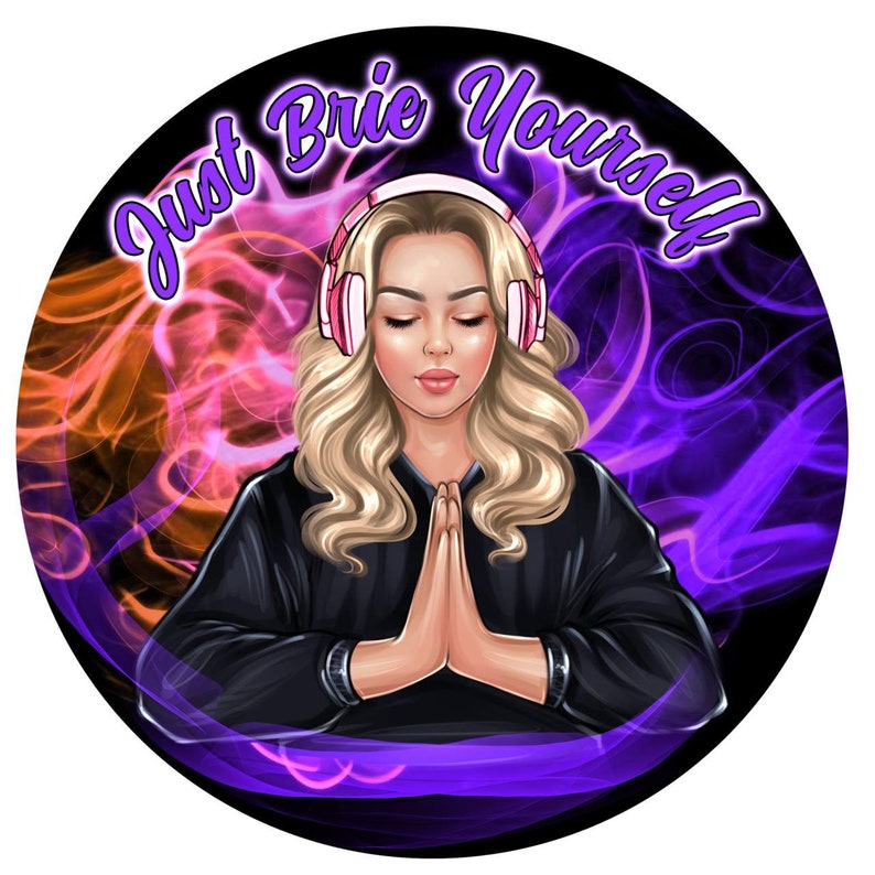 May include: A woman wearing headphones with pink accents sits in a meditative pose with her hands clasped in front of her. The background is a swirling pattern of purple and orange smoke. The text "Just Brie Yourself" is written in a purple font around the edge of the circle.