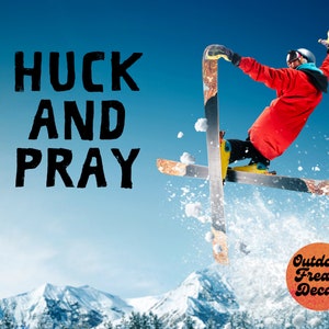 May include: A skier performs a trick in the air, with the words "HUCK AND PRAY" in black text on a blue sky background. The skier is wearing a red jacket and a black helmet. The skier is in the air with skis crossed. The words "Outdoor Freaks Decals" are in a circle with a red, orange, and yellow gradient on a white background.