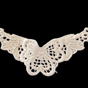 May include: A white lace butterfly applique with a delicate design. This embellishment is perfect for adding a touch of elegance to clothing, crafts, or home decor.