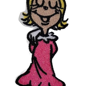 May include: An embroidered iron-on patch featuring a cartoon character with blonde hair, a red bow, and a pink dress. The character is smiling and has a happy expression.