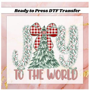 May include: A Christmas-themed DTF transfer design with the words "JOY TO THE WORLD". The design features a Christmas tree, a red and white plaid bow, and the letters "J" and "Y" decorated with green leaves and red berries.