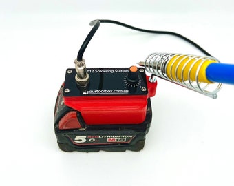 May include: A black soldering station with a red lithium-ion battery pack. The station has a knob for temperature control and a label that reads "T12 Soldering Station" and "yourtoolbox.com.au".
