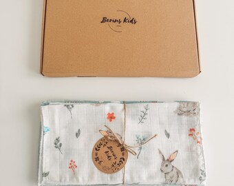 May include: A set of baby muslin cloths with a floral and bunny print, tied with twine and a tag that reads "Berins Kids". The cloths are displayed with a matching cardboard box, also branded with the "Berins Kids" logo.