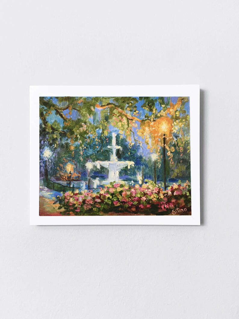 May include: An oil painting of a park scene at dusk. A white fountain is the focal point, surrounded by pink flowers and lush greenery. The painting captures the soft glow of streetlights and the evening sky.