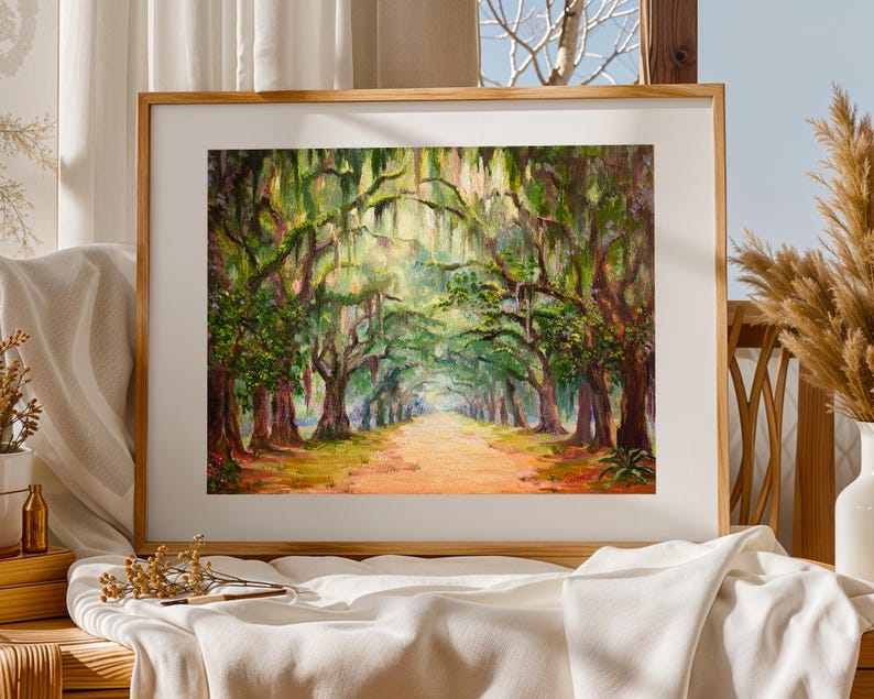 May include: A framed landscape painting showing a tree-lined path. The artwork uses a vibrant palette of greens, browns, and yellows, focusing on the trees and the path leading into the distance. The painting is set in a wooden frame.