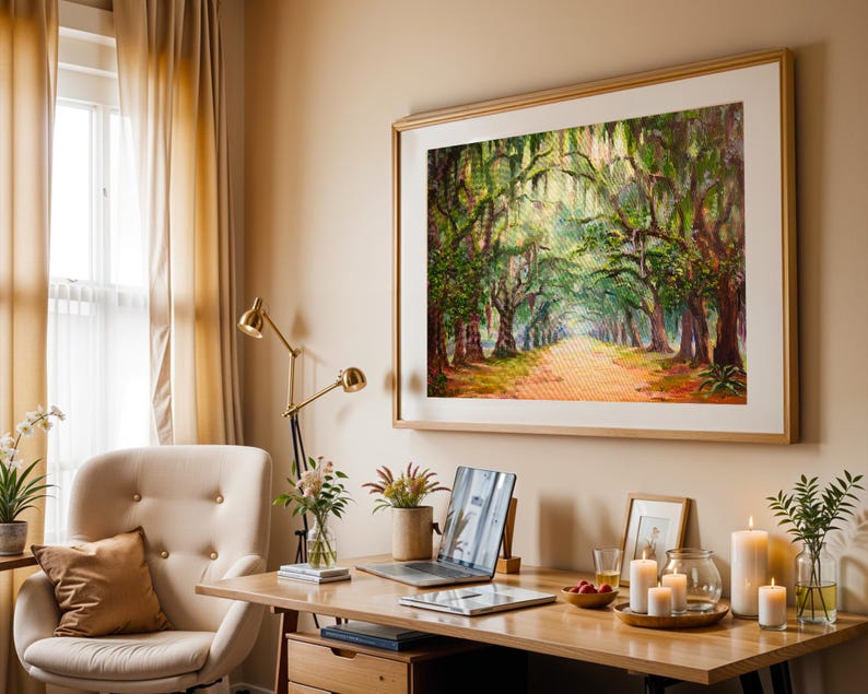 May include: A home office featuring a large framed painting of a tree-lined path. A desk with a laptop, candles, and plants sits in front of a cream-coloured chair. A gold desk lamp and beige curtains complete the warm, inviting space.