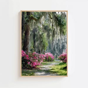 May include: A framed landscape print depicts a path winding through a lush forest. Pink flowering bushes line the path, with Spanish moss hanging from the trees. The artwork is in a wooden frame.