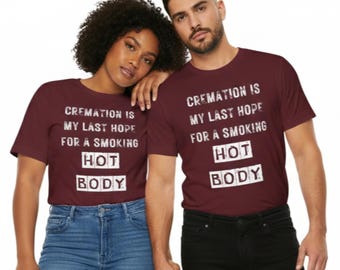May include: Two people wearing matching maroon t-shirts with the text "CREMATION IS MY LAST HOPE FOR A SMOKING HOT BODY" in white block letters. One person wears blue jeans, the other wears black pants.