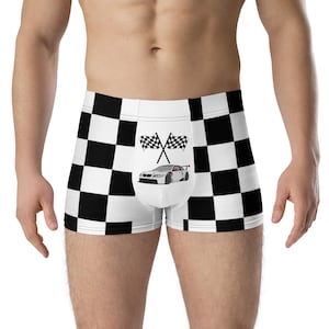 Op de afbeelding: Witte boxershorts met een zwart-wit geblokt patroon. De voorkant heeft een afbeelding van een raceauto en gekruiste geblokte vlaggen. De shorts zijn gemaakt van een zacht, comfortabel materiaal.
