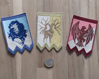 May include: Three embroidered patches with different designs. The first patch is blue and white with a blue wolf design. The second patch is yellow and white with a brown deer design. The third patch is red and white with a red eagle design.