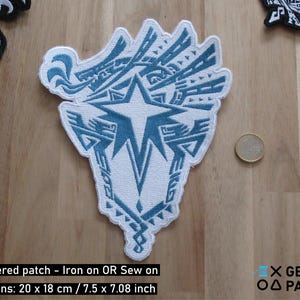 May include: White embroidered patch with a blue star and intricate design. The patch is 7.5 inches by 7.08 inches and can be ironed or sewn onto fabric.