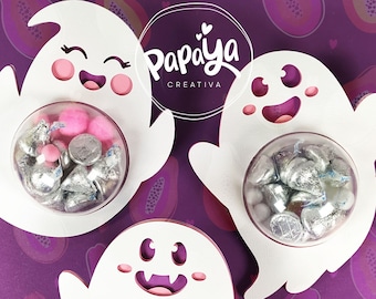 May include: Three white ghost-shaped Halloween treat holders with clear plastic containers filled with silver and pink candies. The ghosts have pink accents and friendly faces. The background is a purple and pink pattern of papaya fruit.