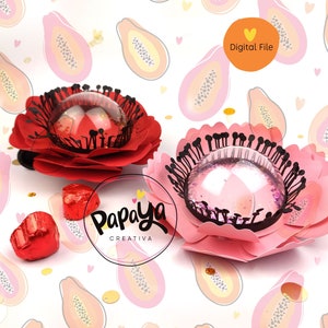 Puede incluir: Dos arreglos florales de papel con una cúpula transparente en el centro. Las flores son rosas y rojas y tienen un contorno negro. El fondo es un patrón rosa y blanco de fruta de papaya. El texto "Papaya Creativa" está en la parte inferior central de la imagen.