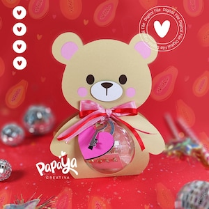 Puede incluir: Un oso de peluche marrón claro sosteniendo una esfera de vidrio transparente con un corazón rosa y una llave plateada en su interior. El oso lleva una cinta rosa alrededor del cuello. El fondo es rojo con ilustraciones de fruta de papaya y pequeños corazones.