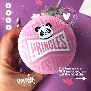 May include: Pink and white round label with a panda bear wearing a bow tie and the text "SPRINGLES" in a white font. The label is for a container of crisps.