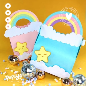 Puede incluir: Dos coloridas bolsas de regalo de papel, una rosa y otra azul, cada una adornada con un arcoíris y una estrella amarilla sonriente. Un borde blanco en forma de nube bordea la parte superior. Las bolsas están sobre un fondo amarillo con bolas de discoteca y cuentas pastel dispersas.