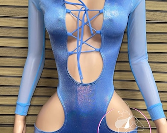 May include: A blue, sparkly bodysuit with long mesh sleeves and a lace-up front. The bodysuit has cutouts on the sides and a V-shaped neckline. The text "Vybrant Custom" is visible in the bottom right corner of the image.