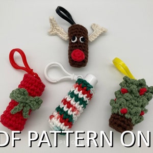 May include: Four crocheted Christmas-themed lip balm holders. The holders are in the shapes of a reindeer, a Christmas tree, and two candy canes. Each holder has a loop for attaching to a keychain.