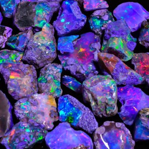 May include: A collection of raw, unpolished opal stones featuring vibrant flashes of neon blue, purple, and green. The stones exhibit a rough, textured surface with iridescent color play, displaying intense light reflections against a dark background.