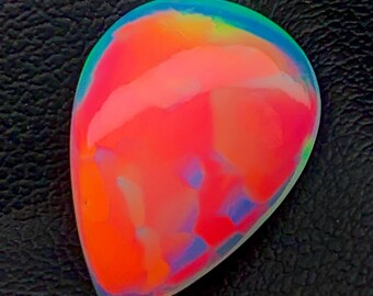 May include: A teardrop-shaped opal gemstone with a vibrant pink, orange, and blue iridescent sheen.
