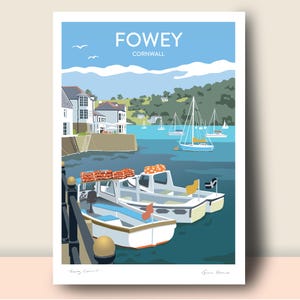 May include: A print featuring a coastal scene of Fowey, Cornwall. The artwork depicts boats docked in a harbor with buildings and green hills in the background. The sky is blue with white clouds and the text "FOWEY CORNWALL" is at the top.