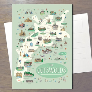 May include: A rectangular postcard featuring an illustrated map of The Cotswolds on a light green background. The map displays various landmarks, buildings, trees, and animals with labels. The title THE COTSWOLDS is printed in white at the bottom.