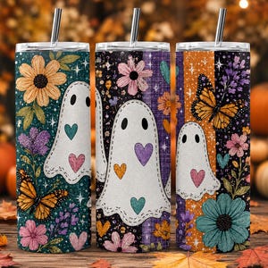 Könnte beinhalten: Drei zylindrische Becher mit Deckeln und Strohhalmen, verziert mit weißen Geistermotiven, bunten Blumen, Monarchfaltern und kleinen Herzen auf dunkelblaugrünen, violetten und orangefarbenen Streifenhintergründen mit Sternen- und Glitzerelementen.